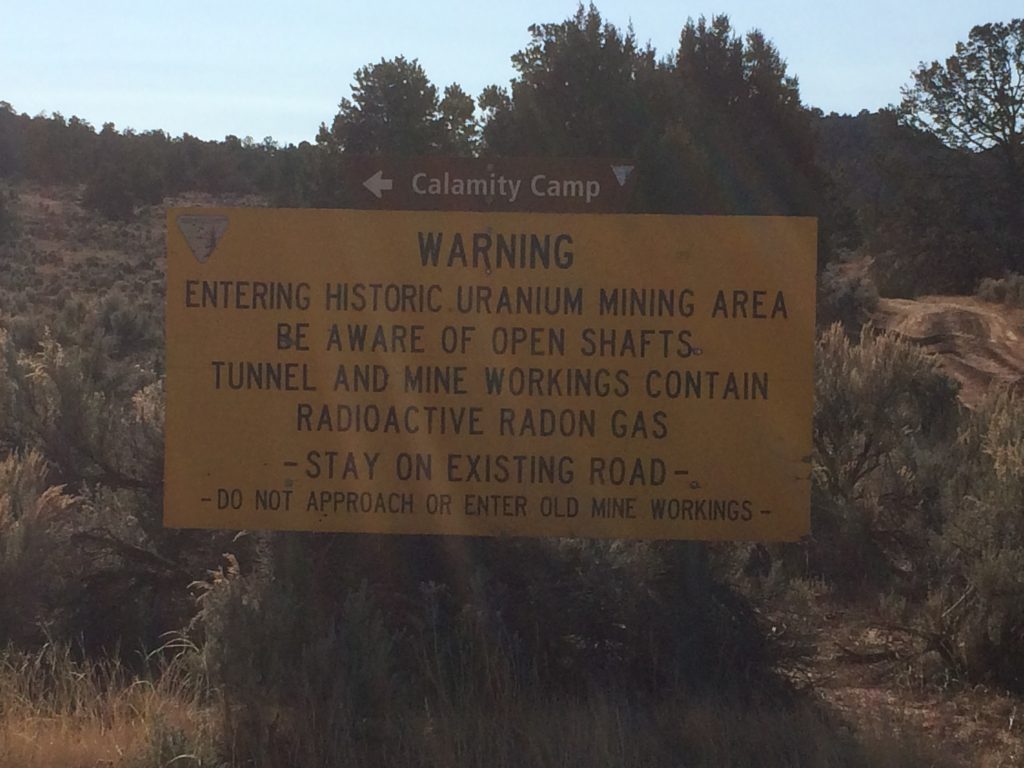 A warning sign as you enter the Calamity Camp reminds visitors of the potential hazards still present around the camp.